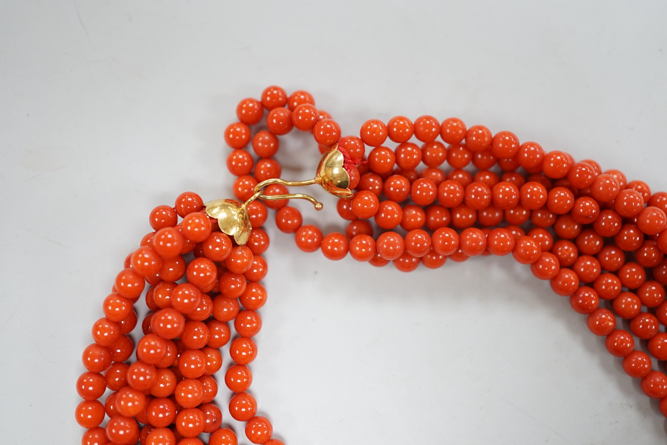 A 1980's Italian multi strand coral bead necklace, with 750 yellow metal clasp and Certificate of Authenticity, 50cm.